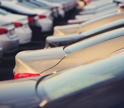New Cars Dealer Stock Closeup Selective Focus. Parking Lot Full of New Vehicles.